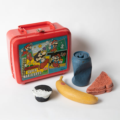 Set of concrete food shaped items with vintage Super Marios Brothers lunch box