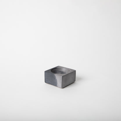 Square concrete incense holder in black and grey.