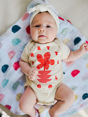 Flowers Onesie on Charli in Cream w/ Red/Orange.