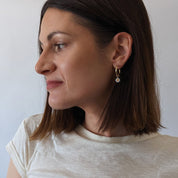 Gold Fill Daisy Charm Hoop Earrings on a model.