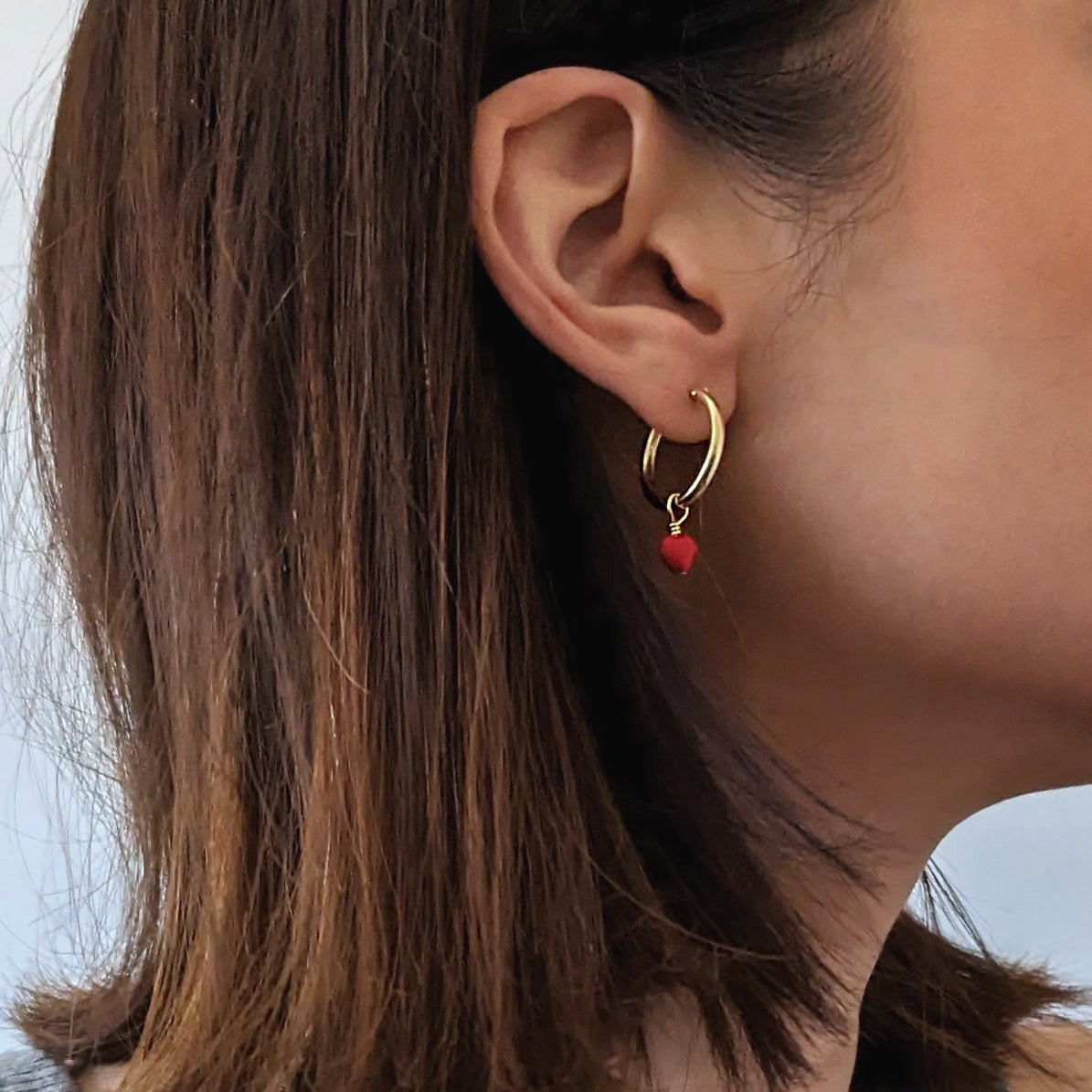 Gold Fill Heart Charm Hoop Earrings on a model.