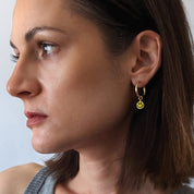 Gold Fill Smiley Charm Hoop Earrings on a model.