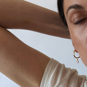 Gold Fill Daisy Charm Hoop Earrings on a model.