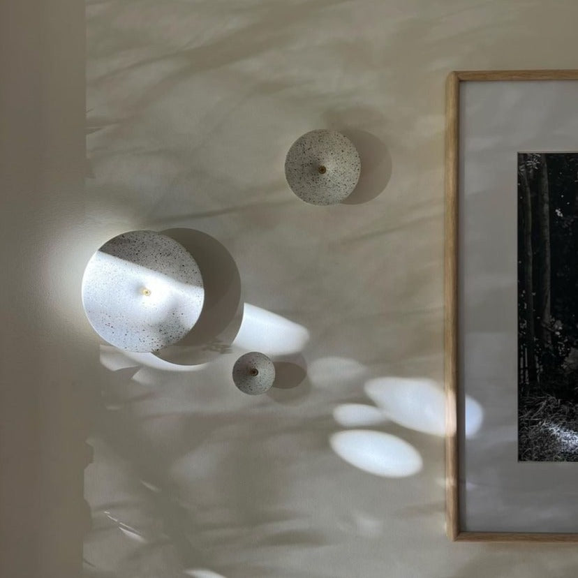 Dimple Wall Hooks in White Terrazzo, shown hanging on a wall.