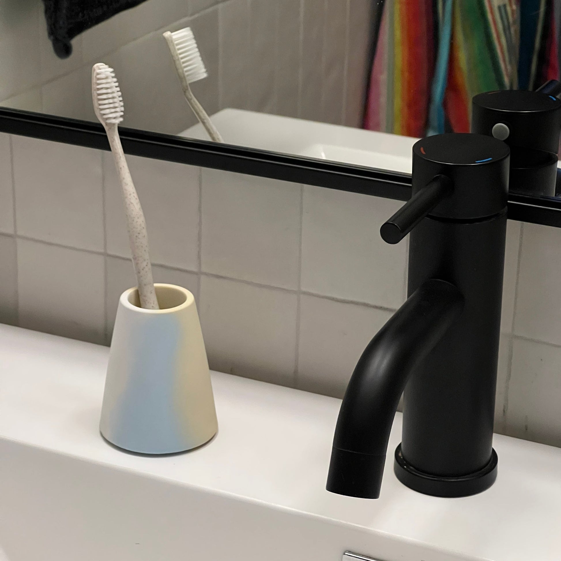 Toothbrush Holder in Jawbreaker Terrazzo, styled by a sink.