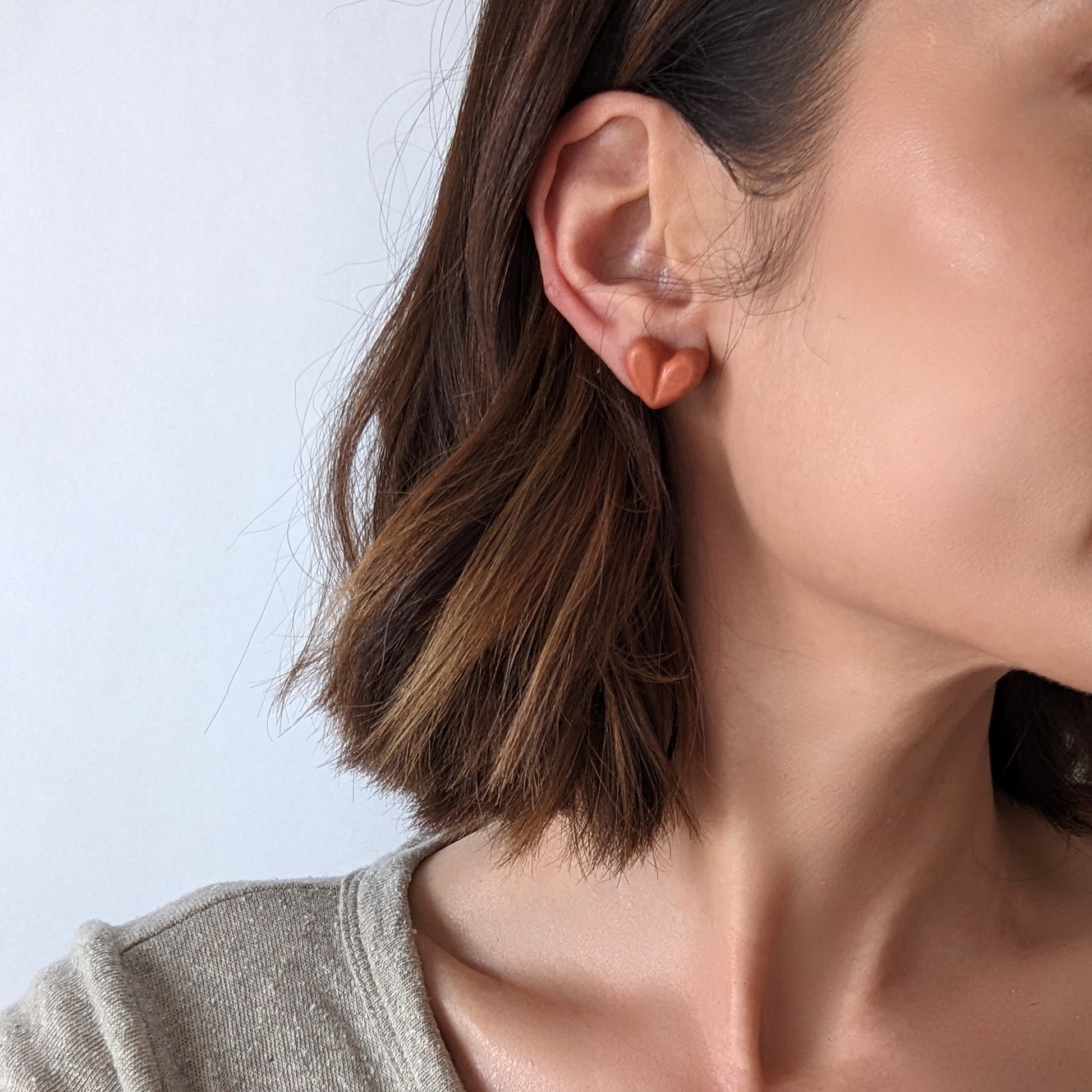 Pretti.Cool's Chunky Heart Earrings in Coral Terrazzo on a model.