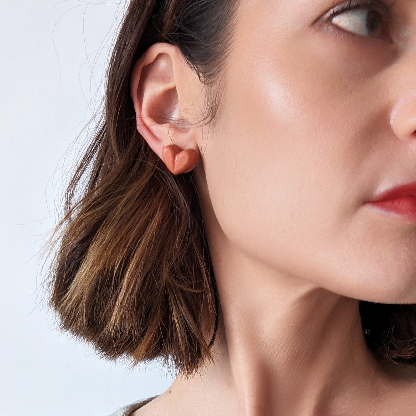 Pretti.Cool's Chunky Heart Earrings in Coral Terrazzo on a model.