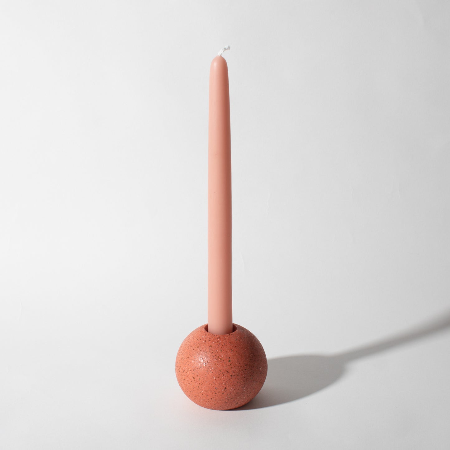 Pretti.Cool Block Candlestick Holders - Sphere in Coral Terrazzo w/ a candle.