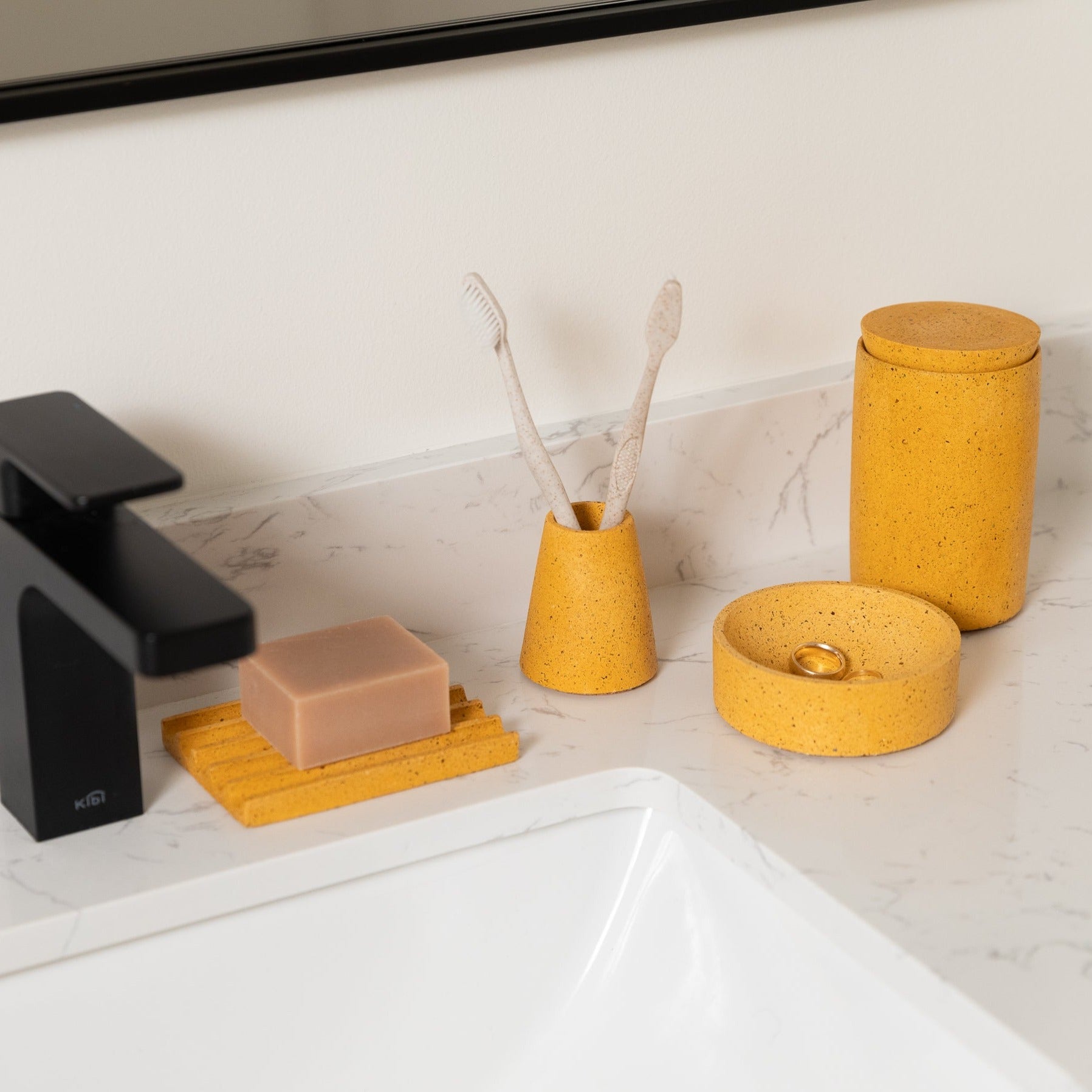 Toothbrush Holder in Marigold Terrazzo, styled by a sink.
