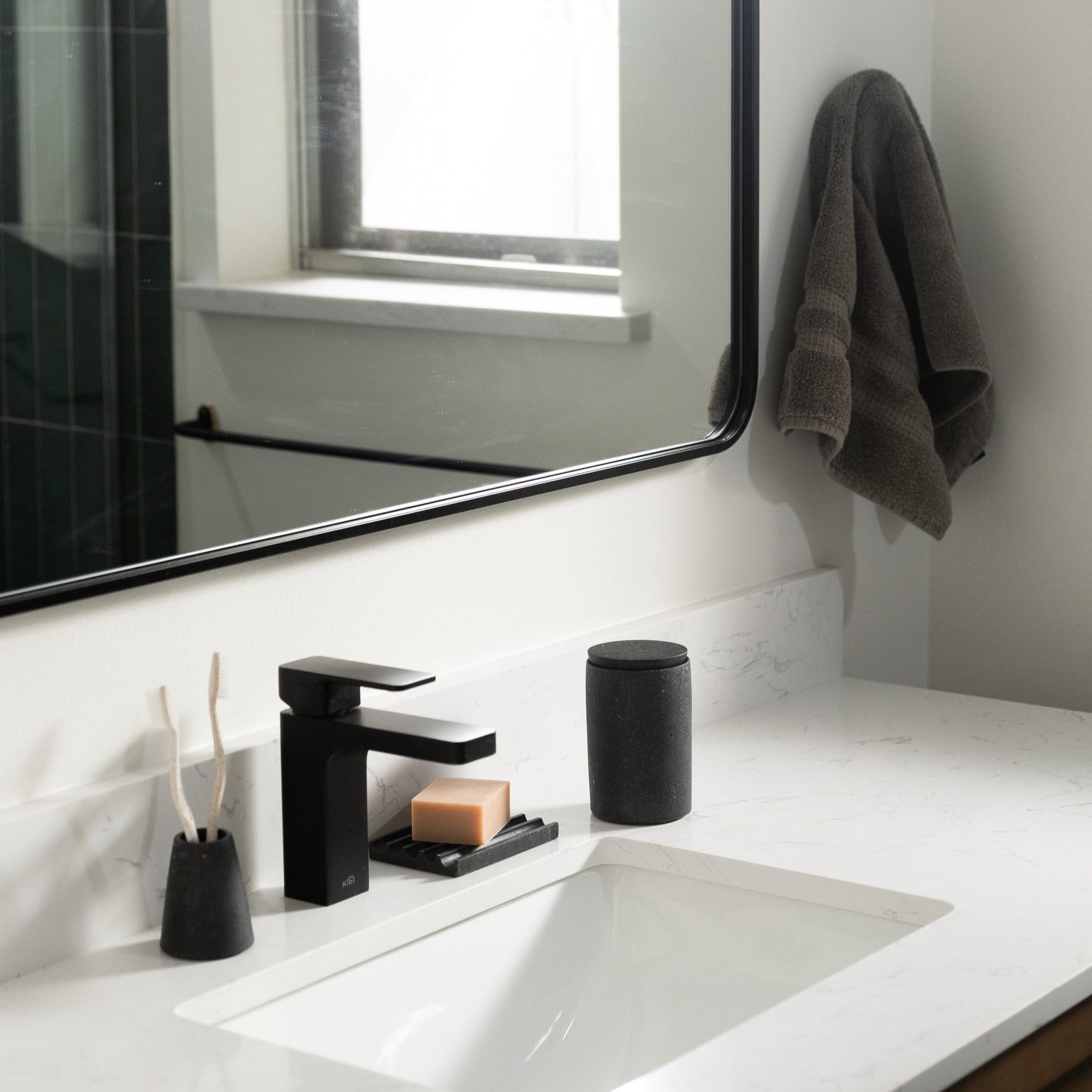 Toothbrush Holder in Black Terrazzo, styled by a sink.