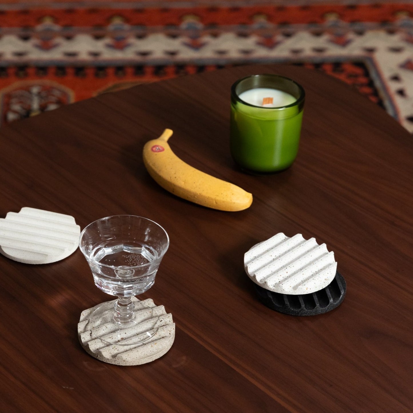 the banana, grey scale coasters, and soy candle, styled.
