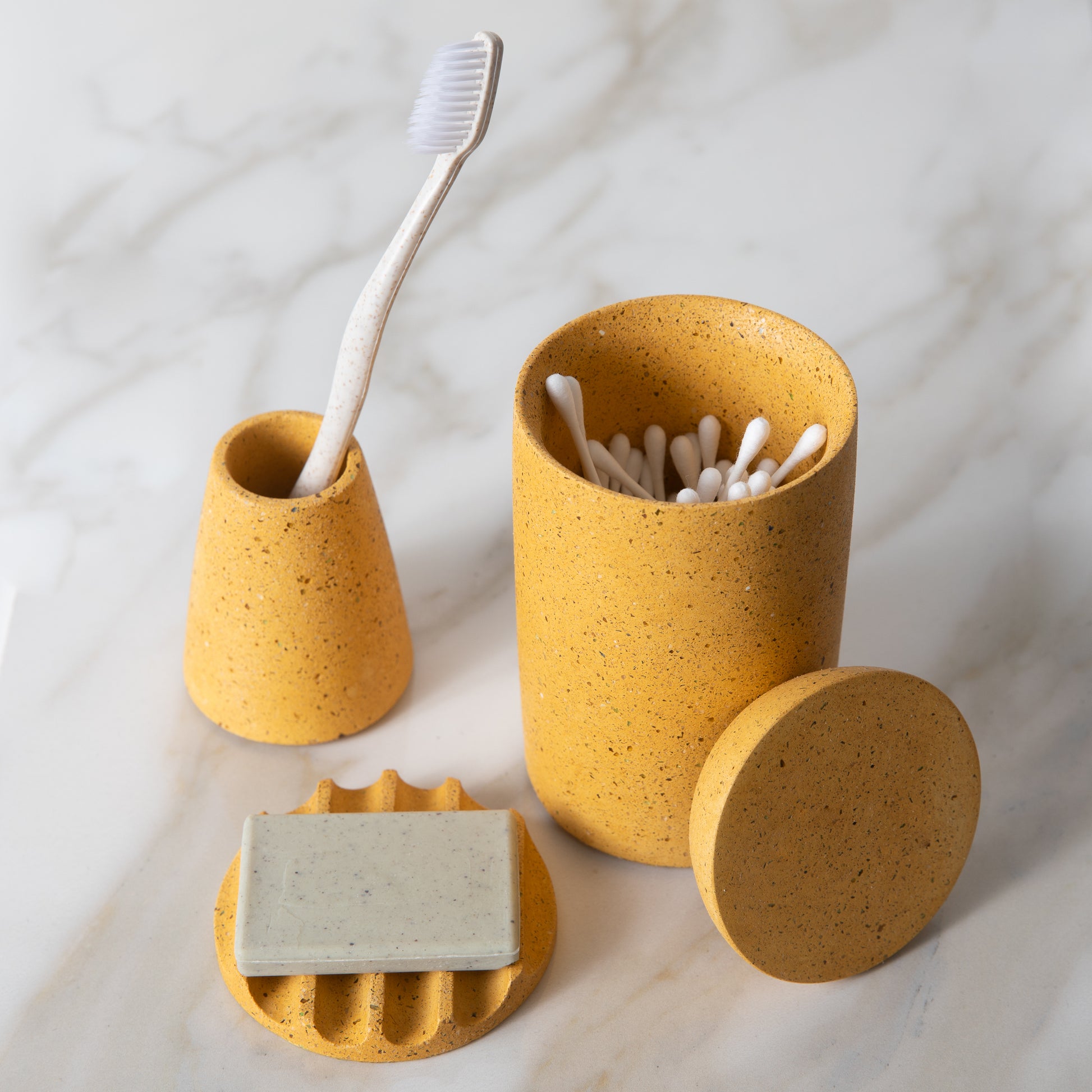 Gentle green toothbrush in our toothbrush holder, next to our mini soap dish and cotton swab holder.
