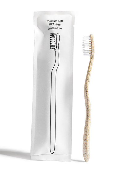 Terra & Co's Gentle Green Toothbrush, pictured next to the packaging it comes in.