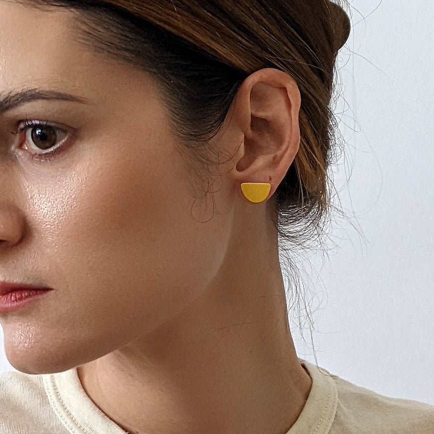 Mound Earrings in marigold, styled on model.