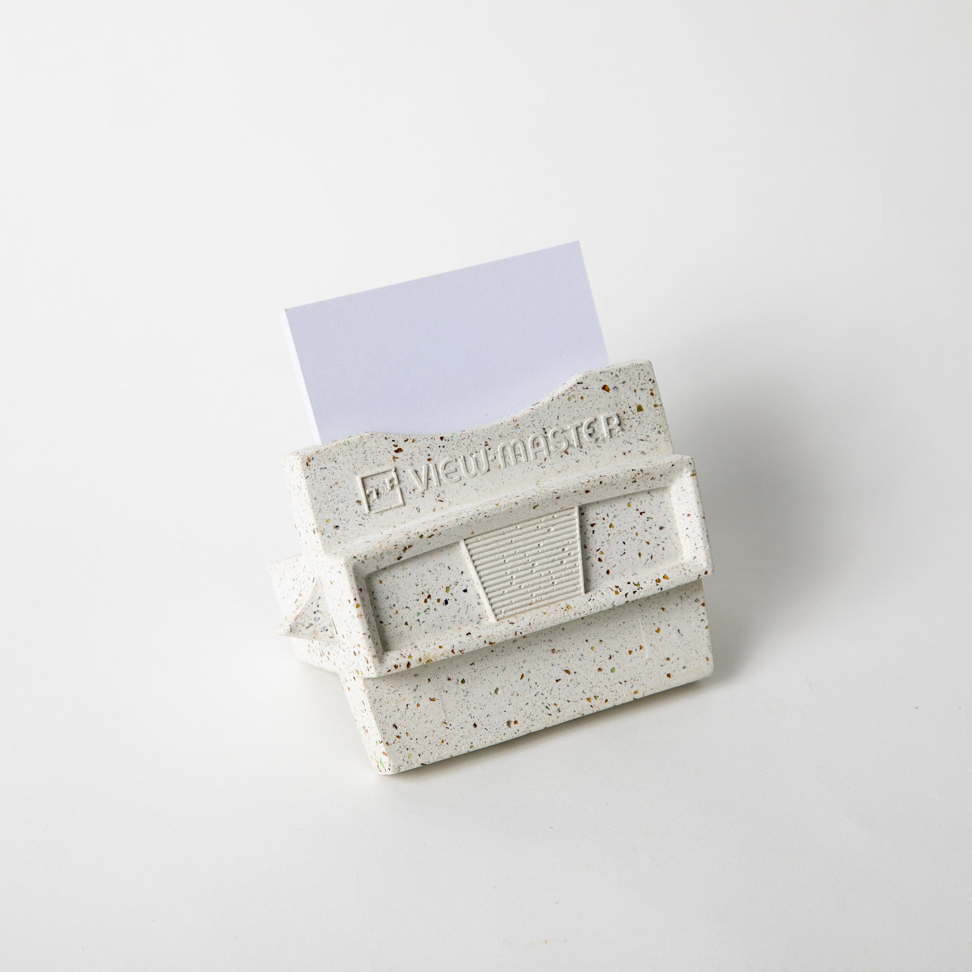 The retro business card holder in white terrazzo w/ blank business cards placed inside.