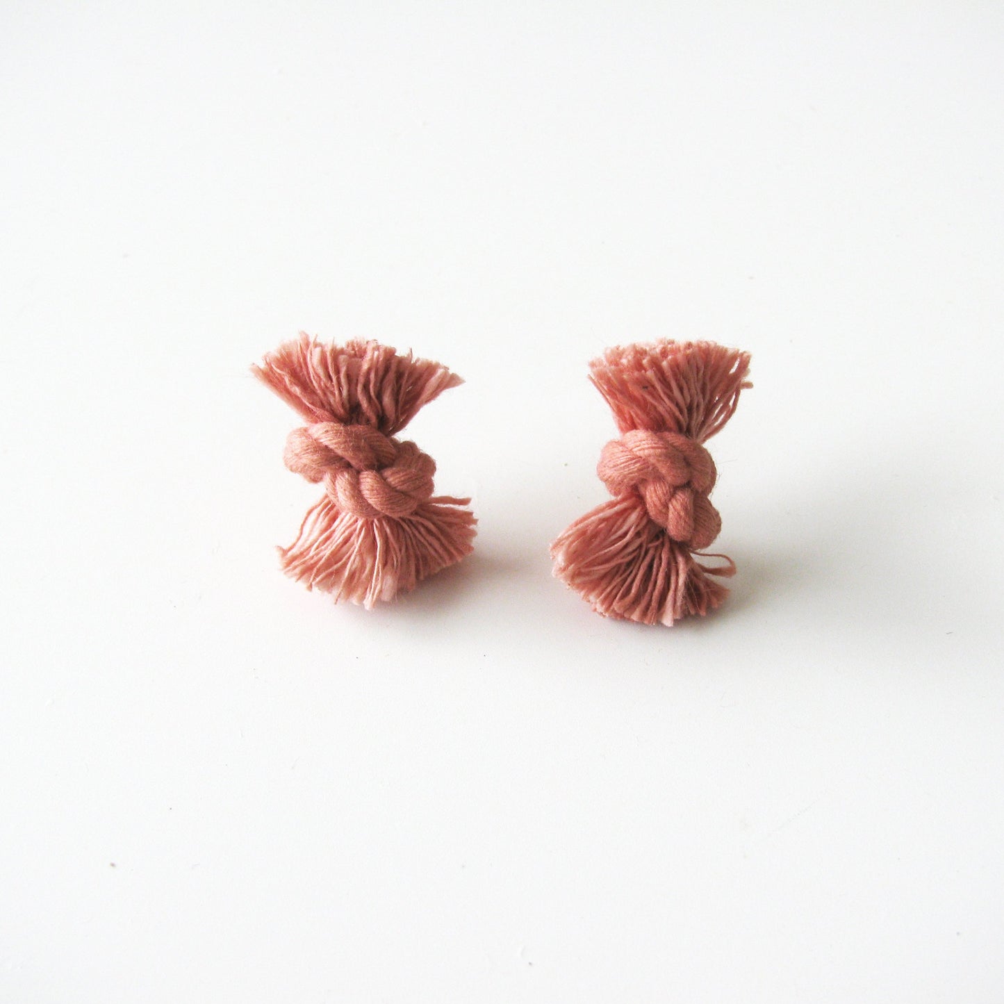 Dyed cotton rope knot earrings with titanium post in coral.