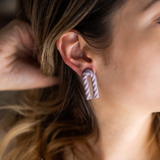  A lightweight dipped rope arch earring that adds a small pop of color and texture.  Materials: linen rope, acrylic coating, titanium post on a woman's ear.