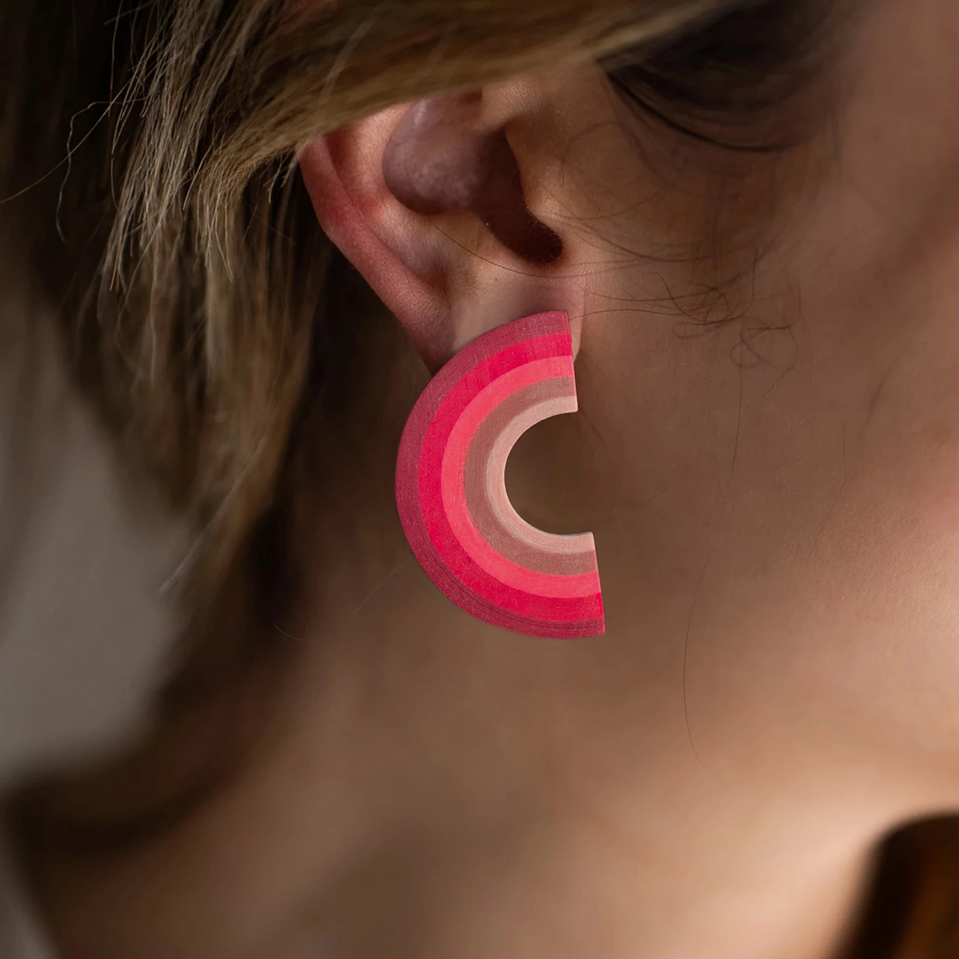 Earrings made from compressed paper with a titanium stud on model's ear.