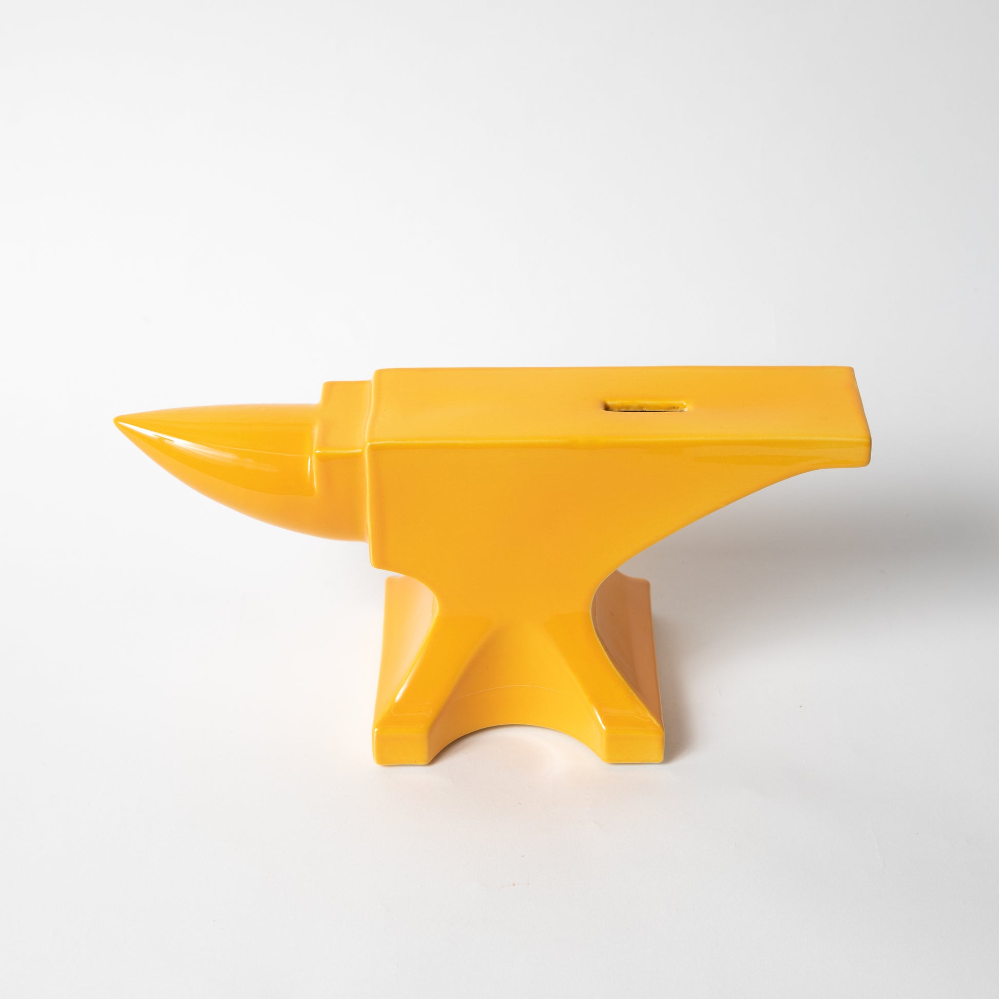 The ceramic Anvil Coin Bank in mango gloss.