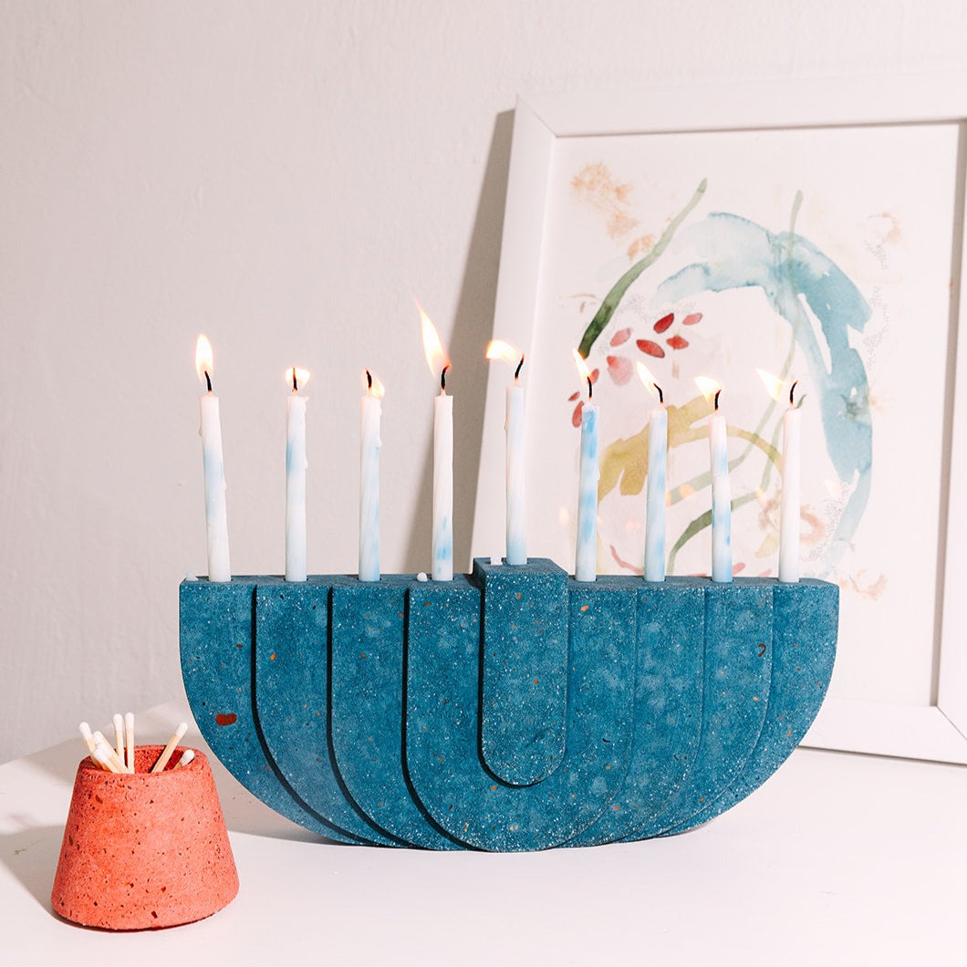 Cobalt terrazzo menorah with a coral terrazzo matchstick holder.