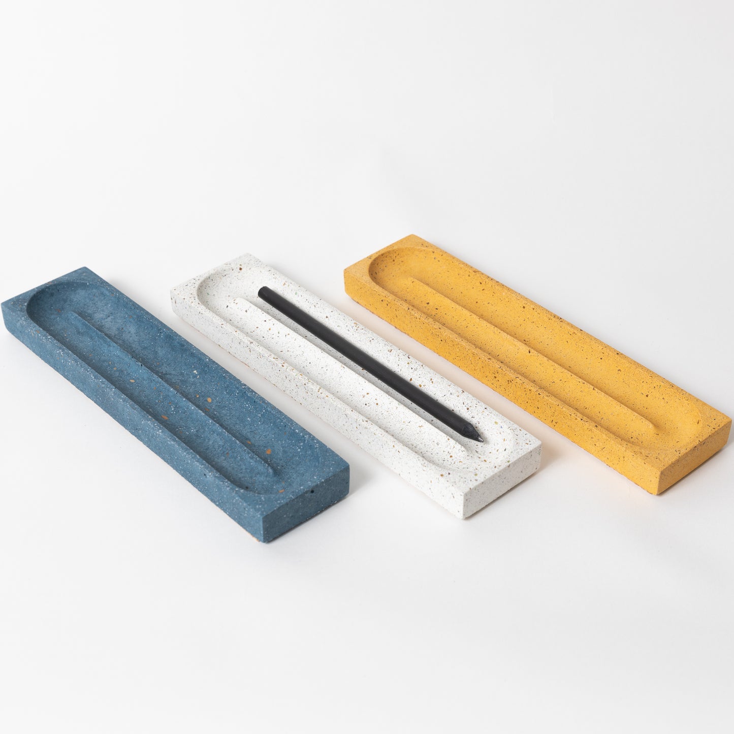 Concrete pencil tray in various terrazzo colors.