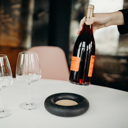 Black terrazzo wine coaster, wine bottle, and glasses.