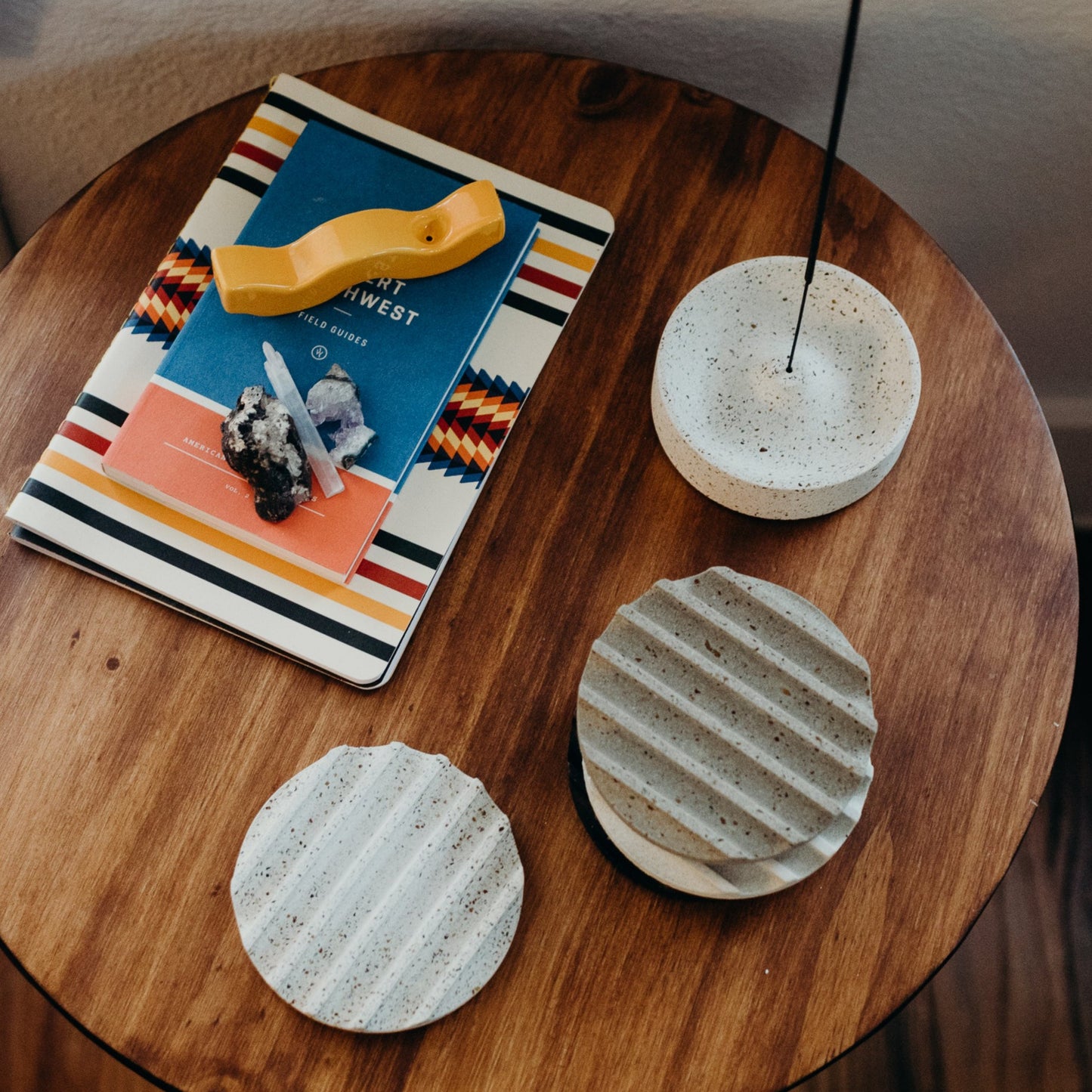 Mango gloss pipe, sitting on a side table next to a set of greyscale terrazzo coasters and white terrazzo incense dish.