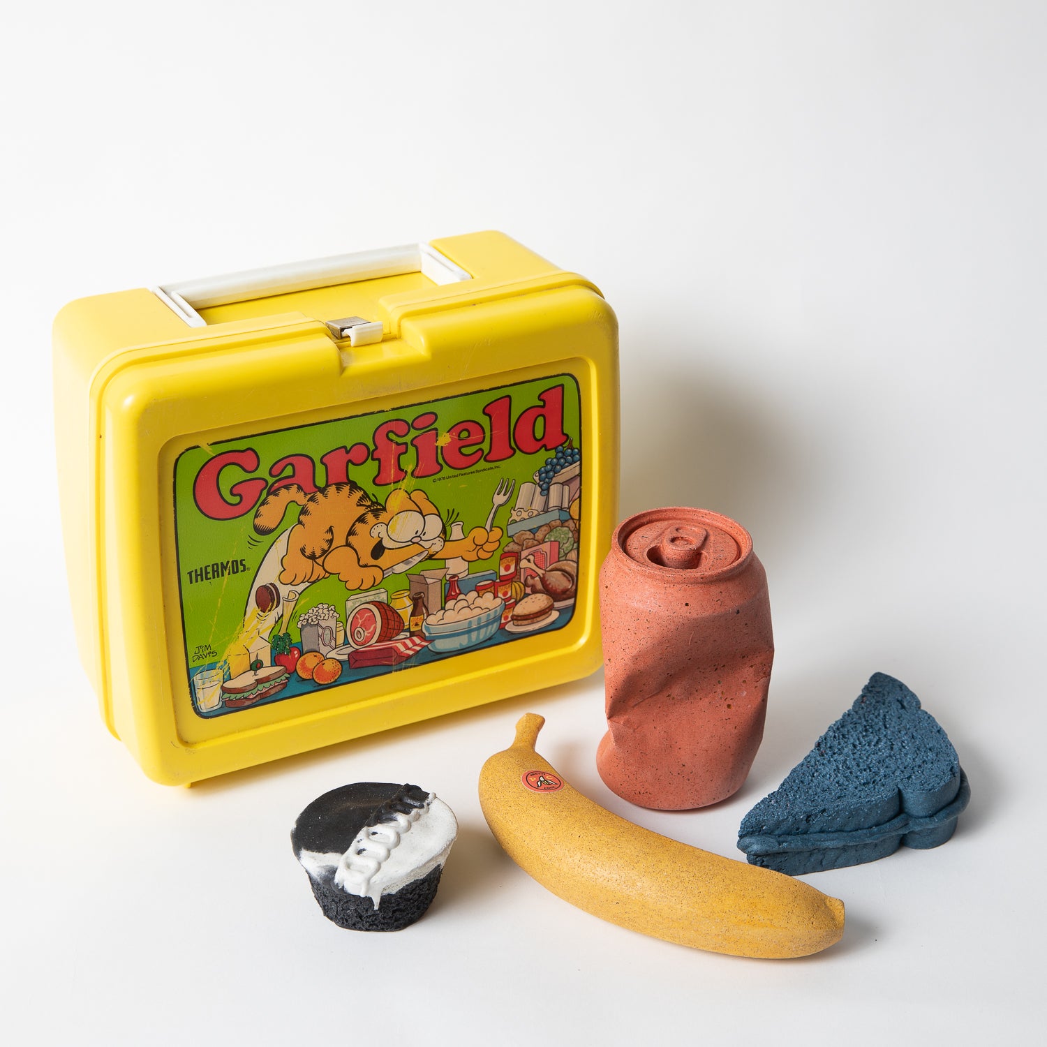 Set of concrete food shaped items with vintage Garfield lunch box