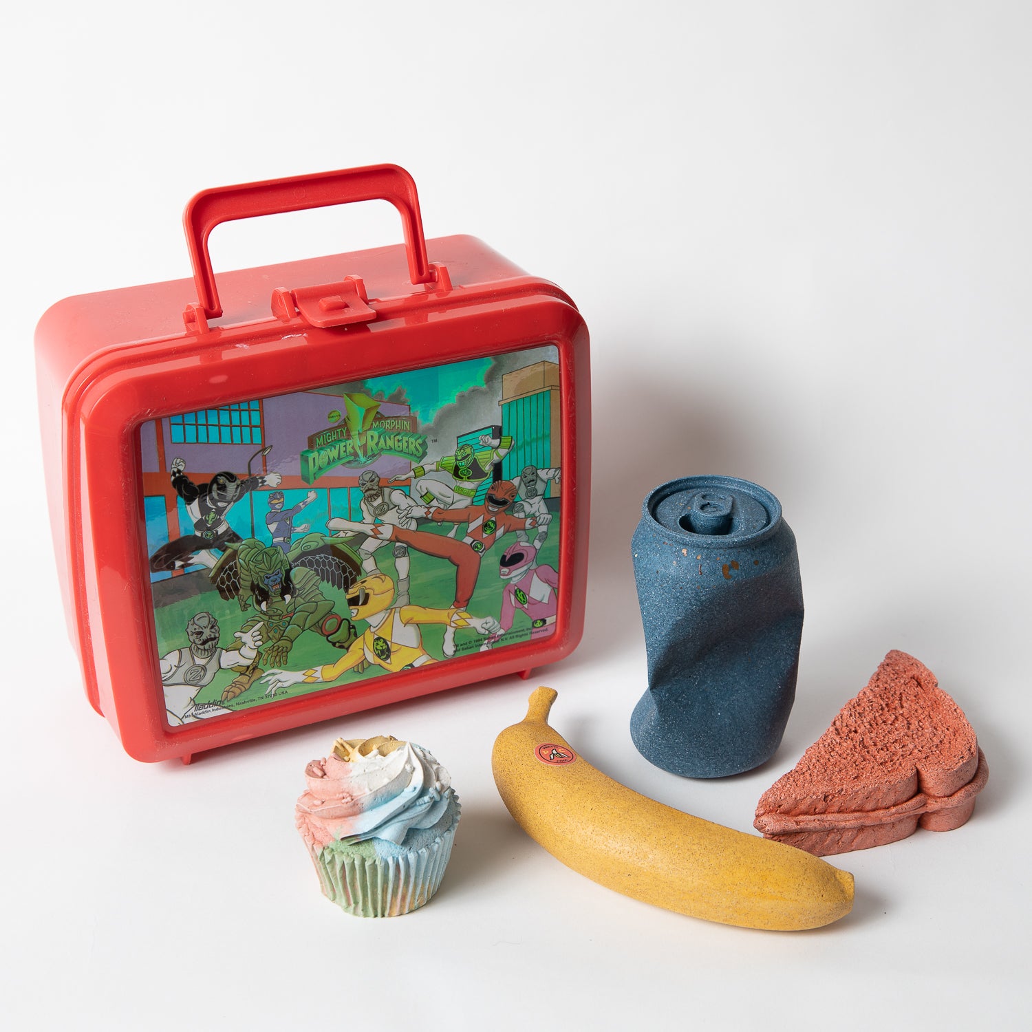 Set of concrete food shaped items with vintage Power Rangers lunch box