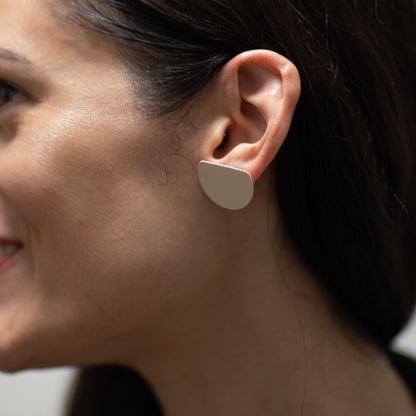 Brass w/ Sterling Posts earrings in white on person's ear.