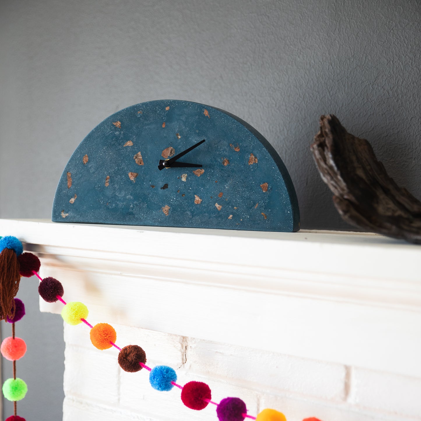 The cobalt terrazzo mantel clock, styled on a mantel.