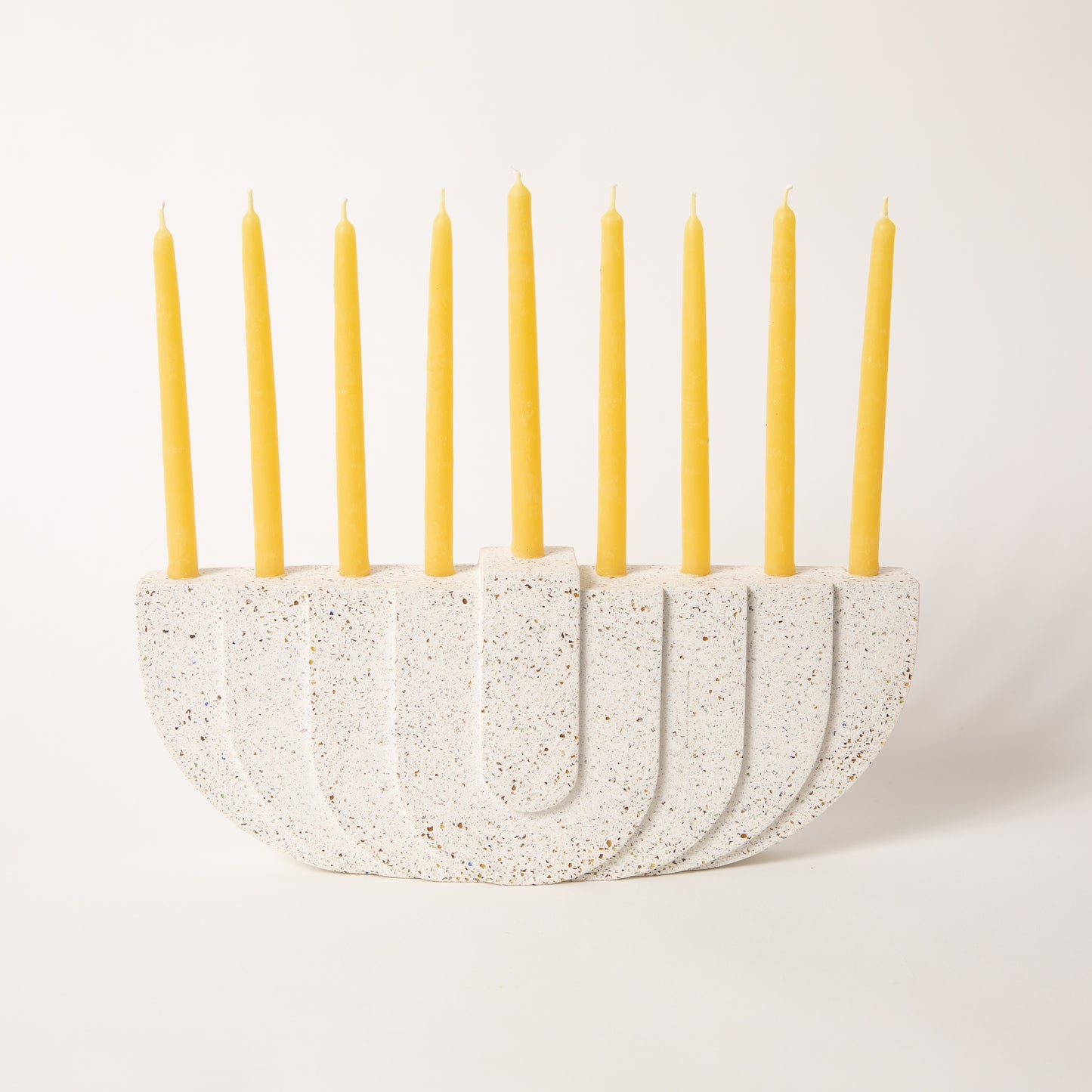 Concrete terrazzo menorah in white with candles.
