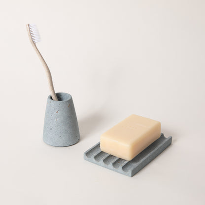 Light blue terrazzo toothbrush holder & soap dish set, styled with a toothbrush & bar of soap.