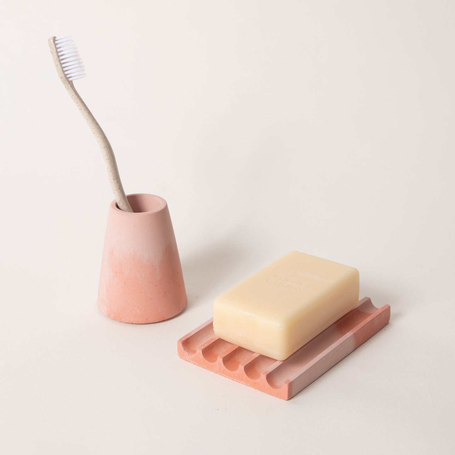 Pink & coral toothbrush holder & soap dish set, styled with a toothbrush & bar of soap.