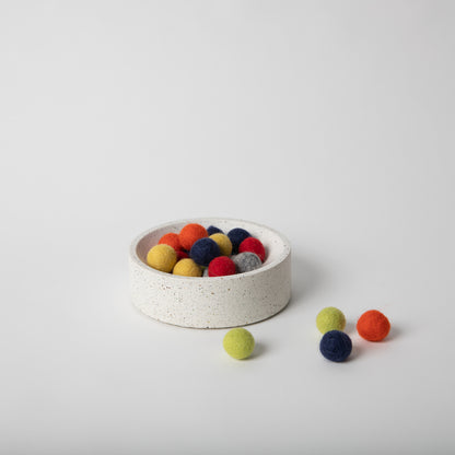 5 inch terrazzo concrete catch all with cork base with felt colored balls in it.