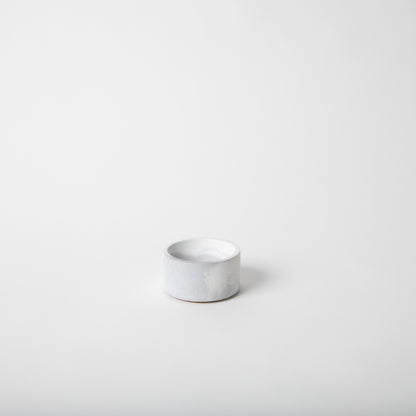 Round concrete incense holder in grey and white.