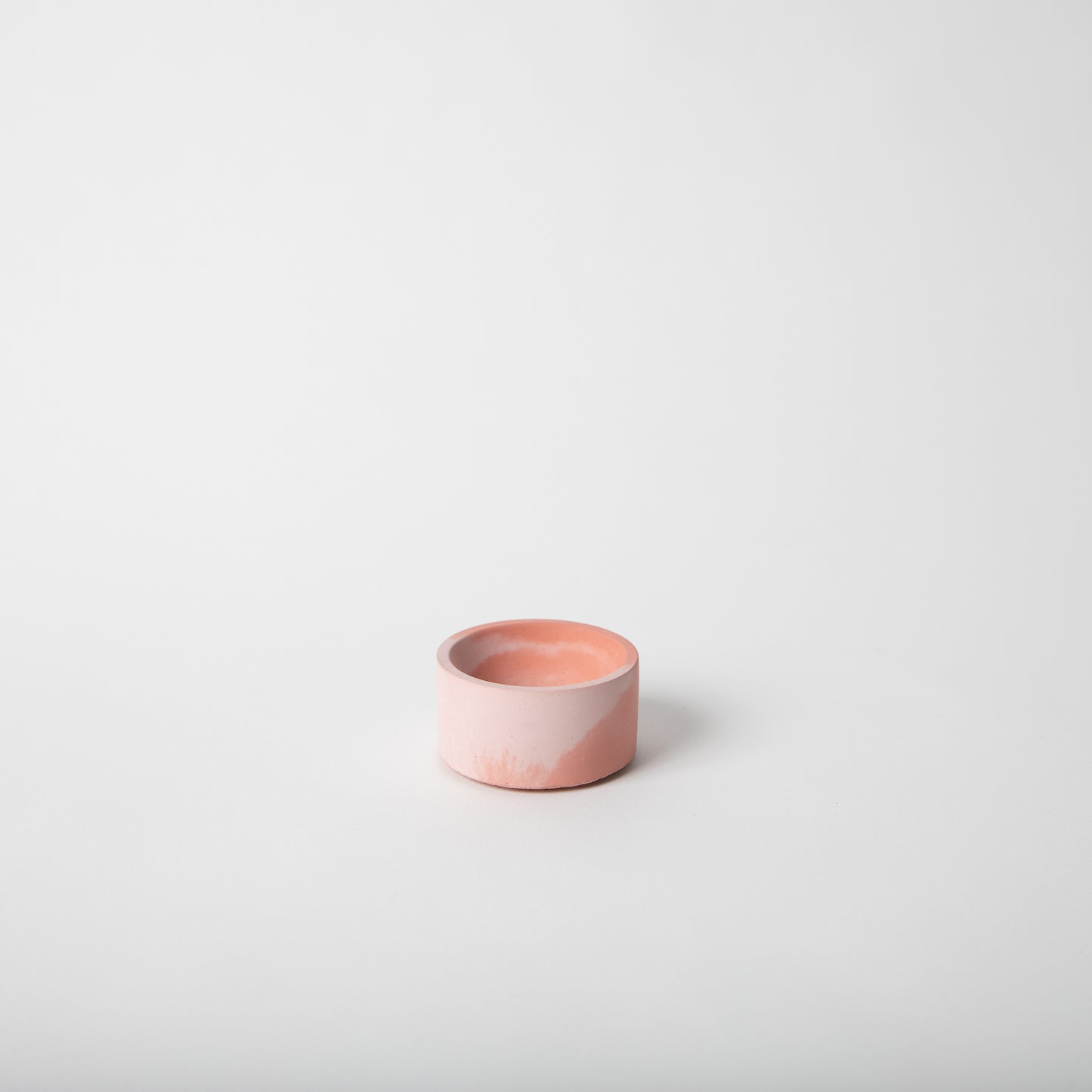 Round concrete incense holder in pink and coral.