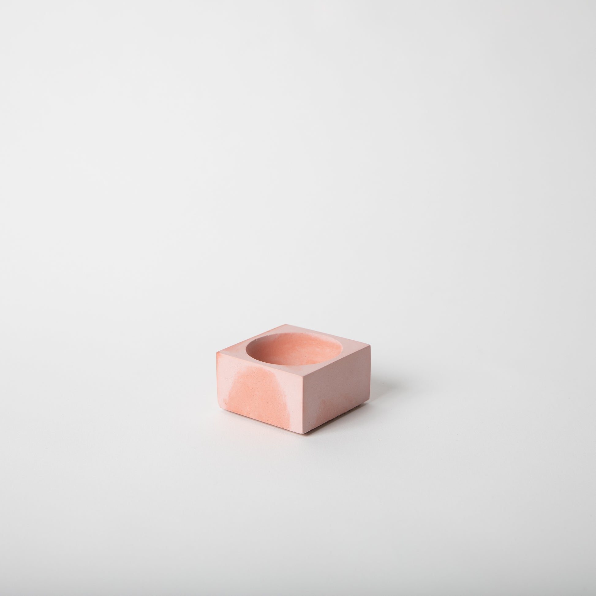Square concrete incense holder in pink and coral.