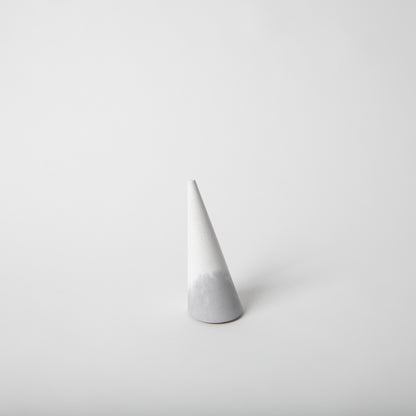 Cone shaped concrete ring holder with cork base in grey and white.
