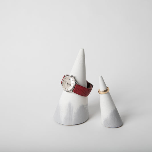 Cone shaped concrete jewelry holder with cork base in grey and white.