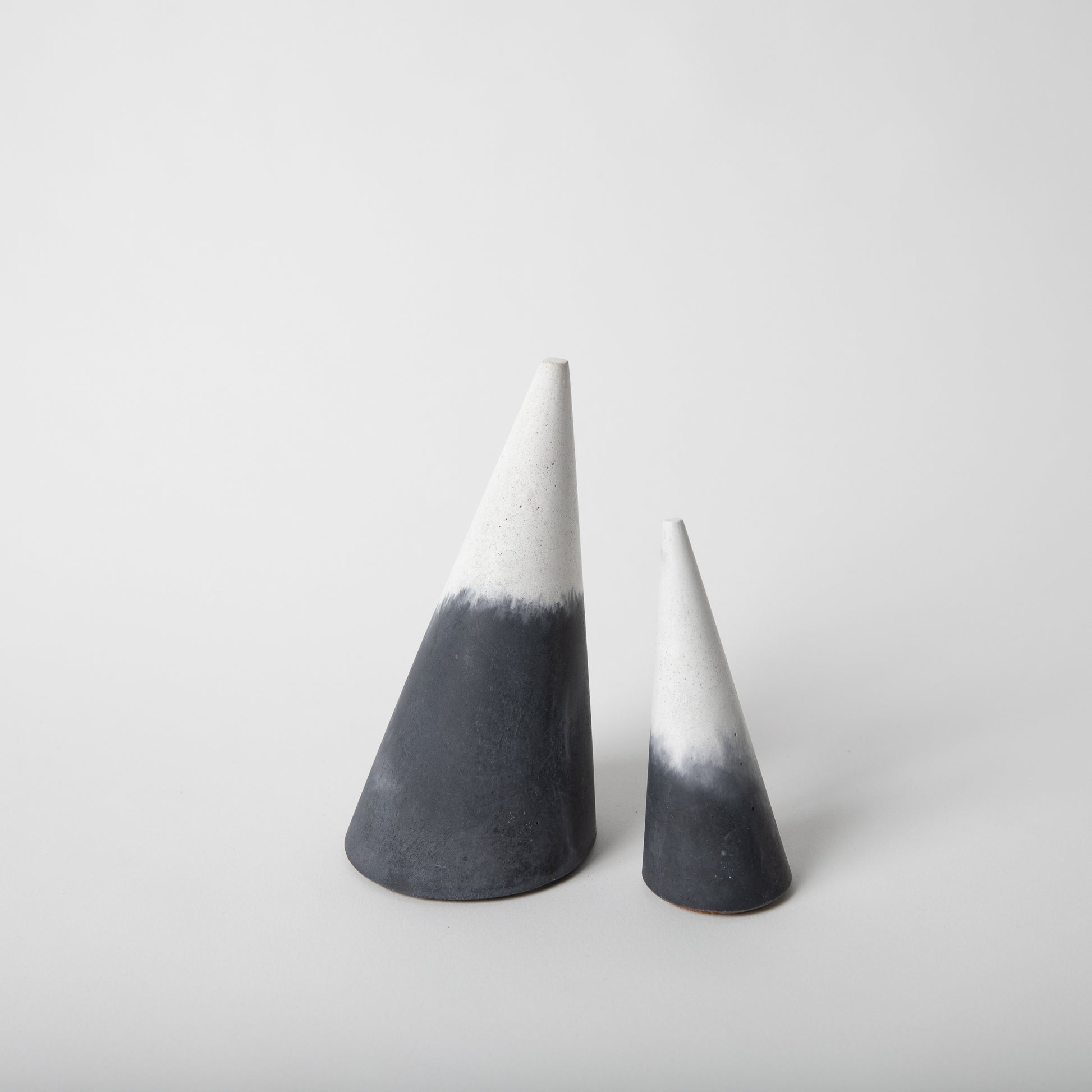 Cone shaped concrete jewelry holder with cork base in black and white.