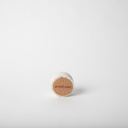 Round concrete incense holder bottom showing cork base.