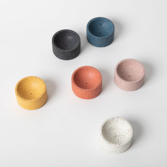 Round terrazzo concrete incense holder in various colors.