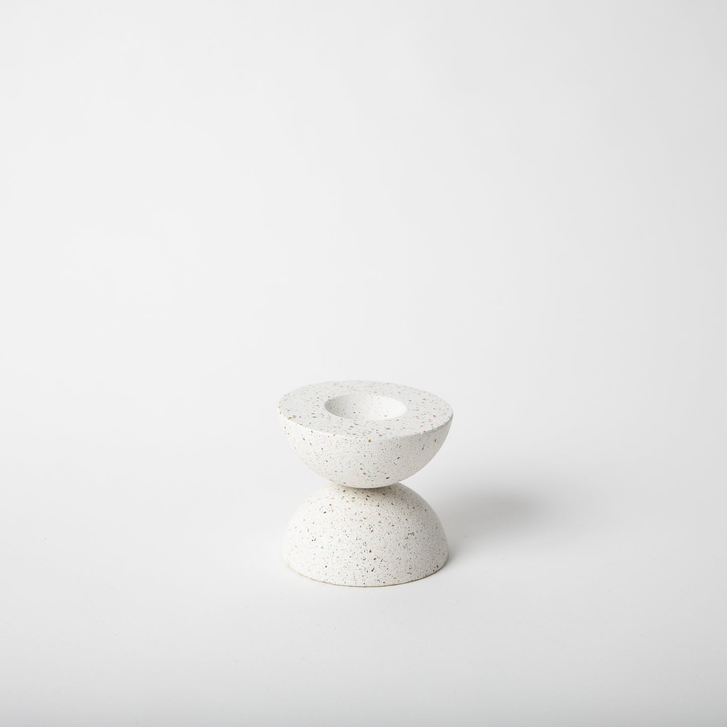 Half sphere shaped incense holder in white terrazzo.