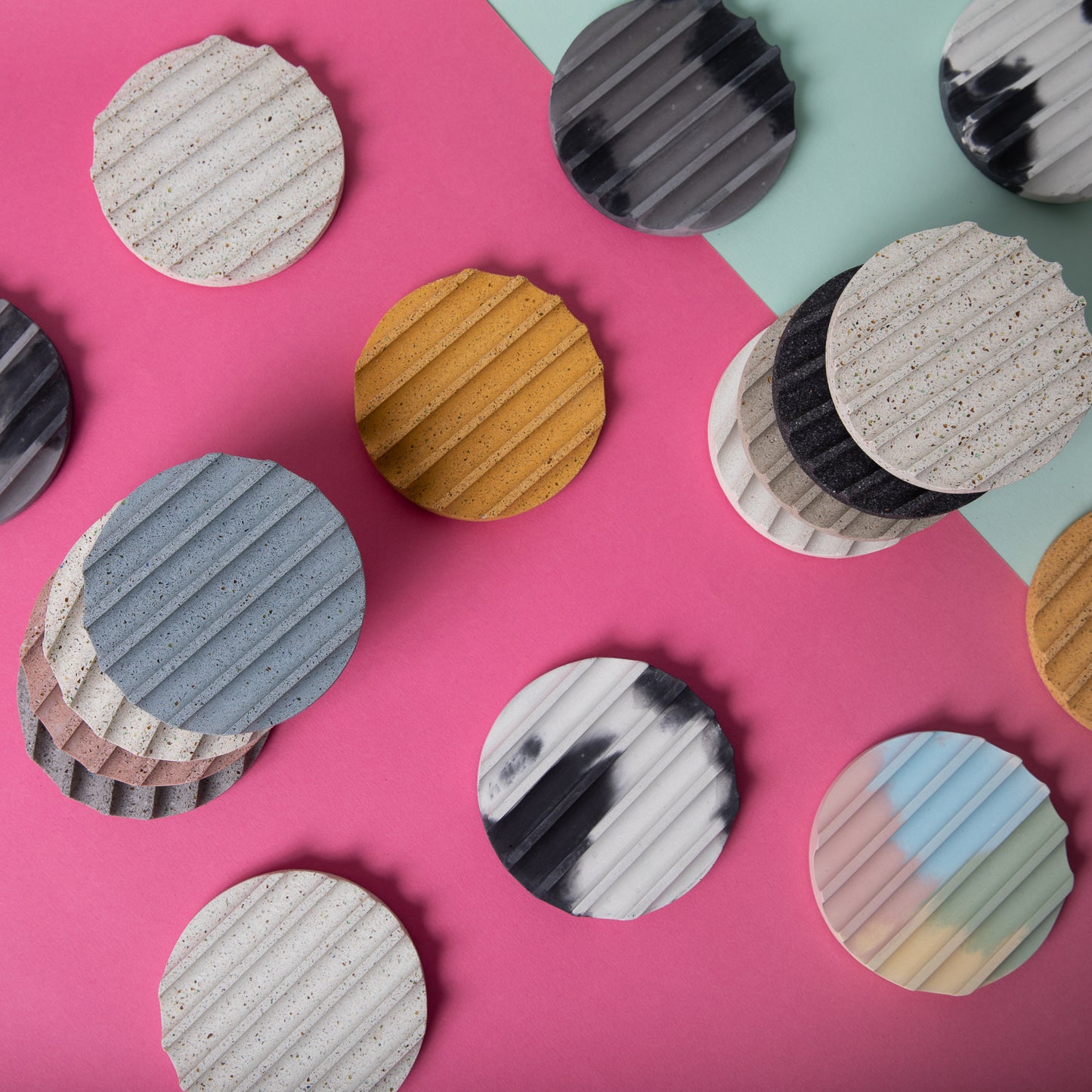 Concrete terrazzo coaster set in grey scale, seen with various colors.