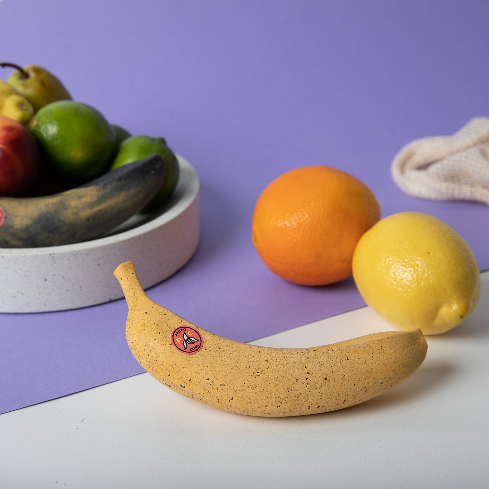 Concrete banana ripe in front of other real fruit.