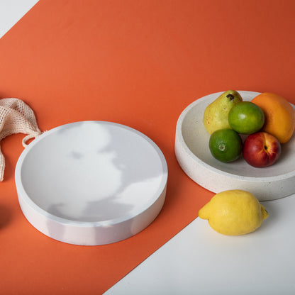 Large concrete centerpiece bowl in both color options holding fruit.