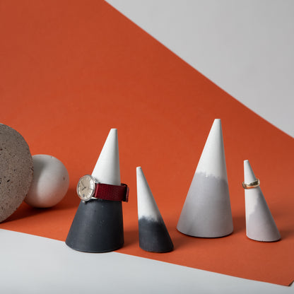 Cone shaped concrete jewelry holder with cork base in black and white, and grey and white.
