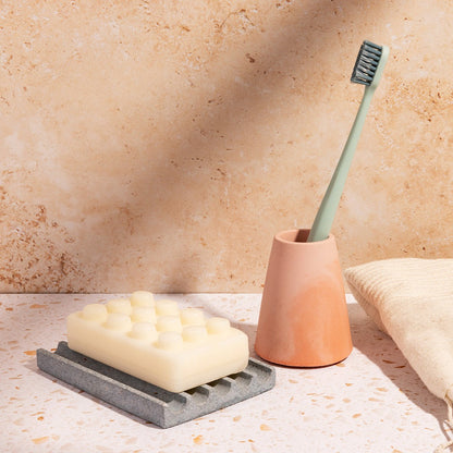 Light blue terrazzo soap dish with a pink & coral toothbrush holder.